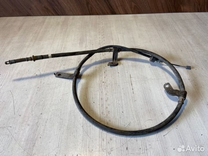 Трос стояночного тормоза левый Kia Rio 3