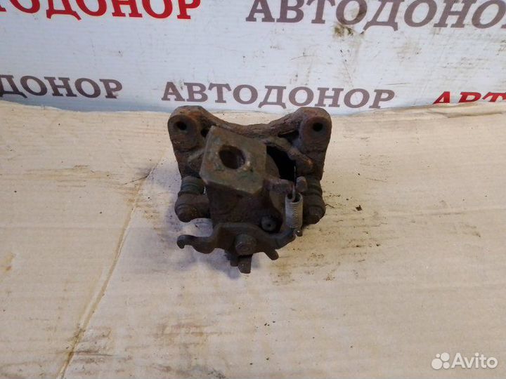 Суппорт тормозной задний левый Nissan Almera Tino