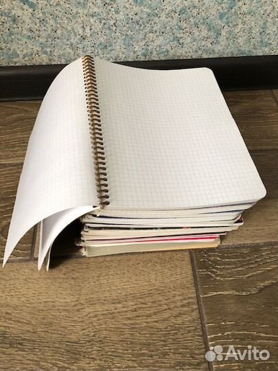 Большая стопка общих тетрадей и тетрадные листы