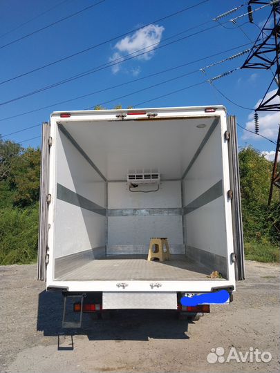 Водитель со своим грузовым автомобилем рефрежерато