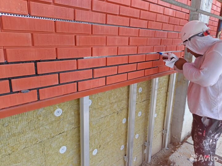 Рабочие на затирку швов на фасаде